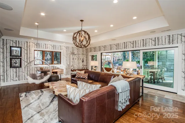 a living room with furniture large window and wooden floor