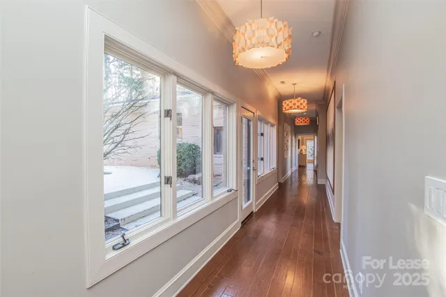 a view of a hallway with wooden floor and staircase