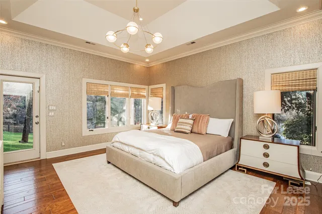 a large white bed sitting in a bedroom next to a window