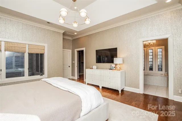 a bedroom with a bed and a flat tv screen on the dresser