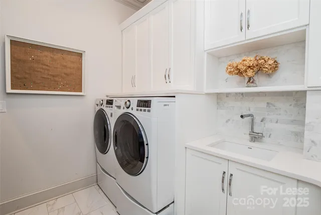 a utility room with sink dryer and washer