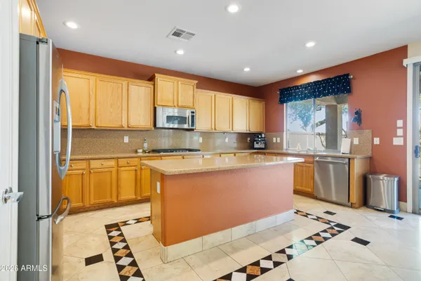 a large kitchen with stainless steel appliances kitchen island granite countertop a sink and cabinets