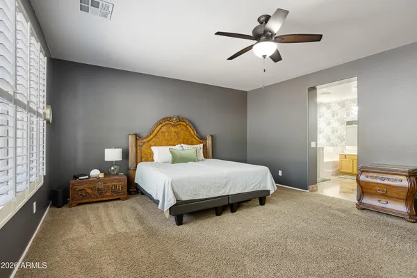 a bedroom with a bed and a ceiling fan