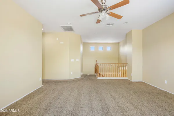 an empty room with a ceiling fan and a window