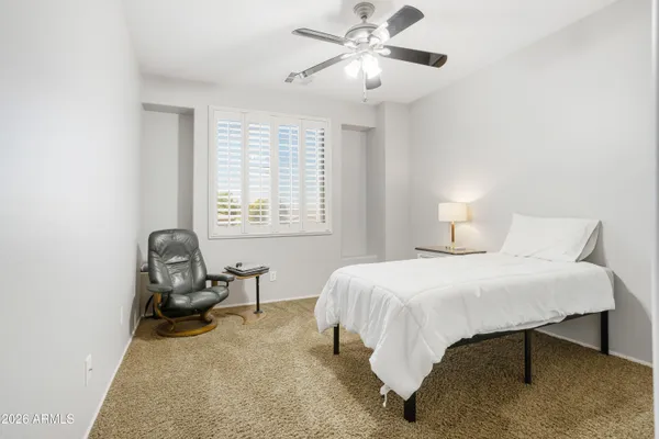 a bedroom with a bed and chair