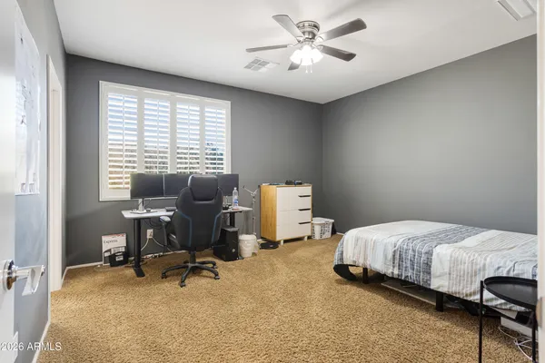a bedroom with a bed a chair and a chandelier