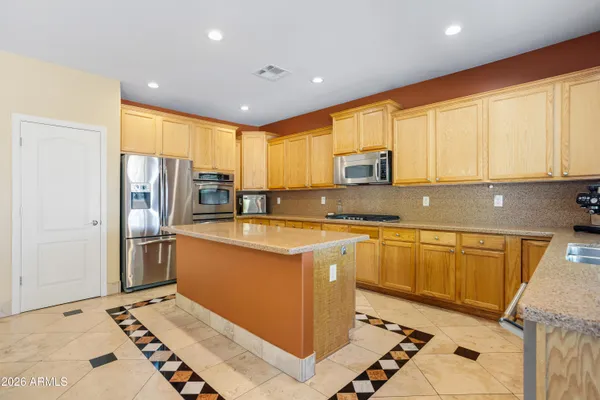 a kitchen with stainless steel appliances granite countertop a refrigerator sink and stove