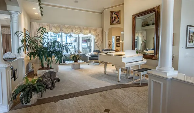 a living room with patio furniture and floor to ceiling window