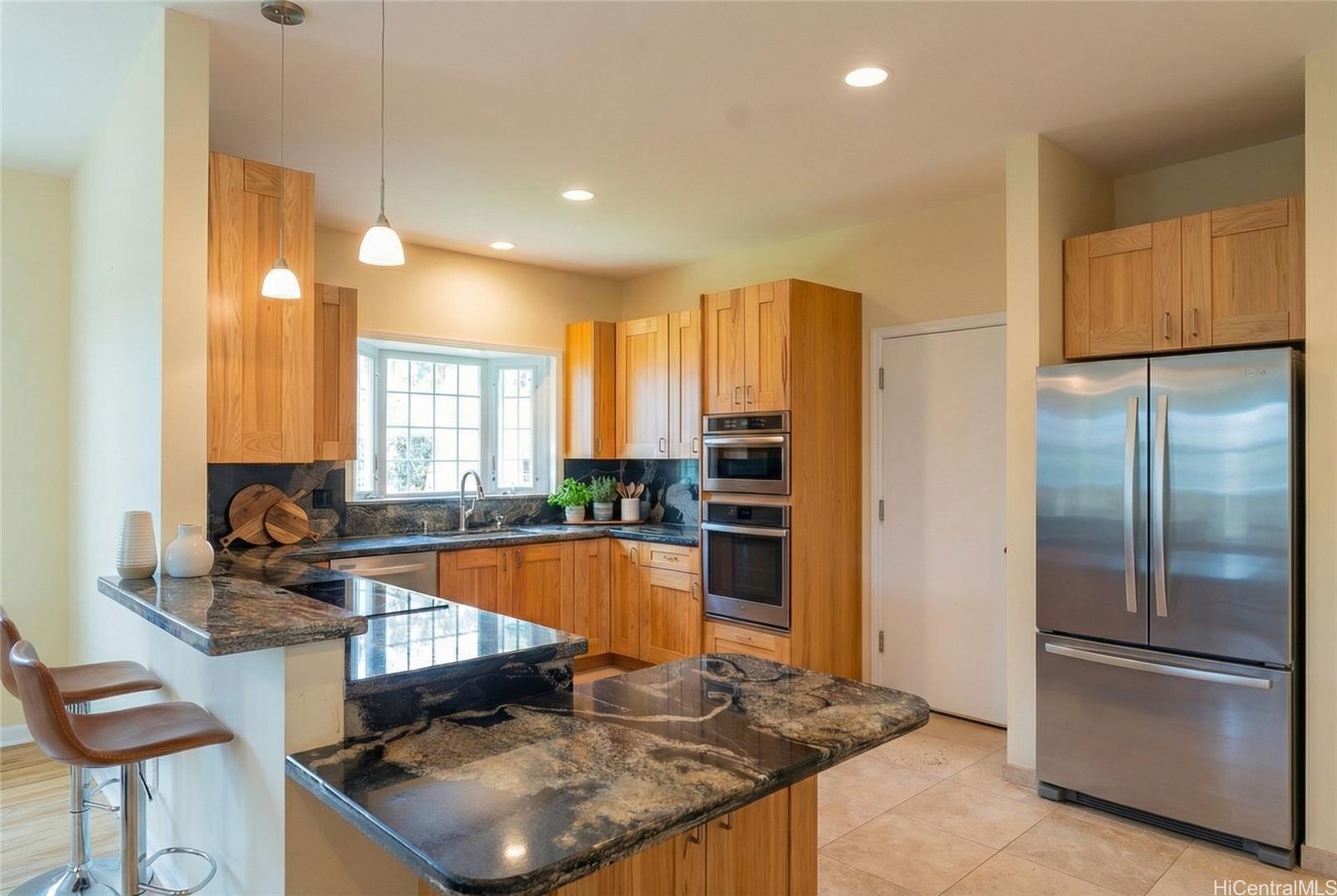 4026 Harding Avenue Honolulu, HI 96816 - Photo 17 of 18 a kitchen with stainless steel appliances granite countertop a refrigerator a stove and a sink with wooden floor