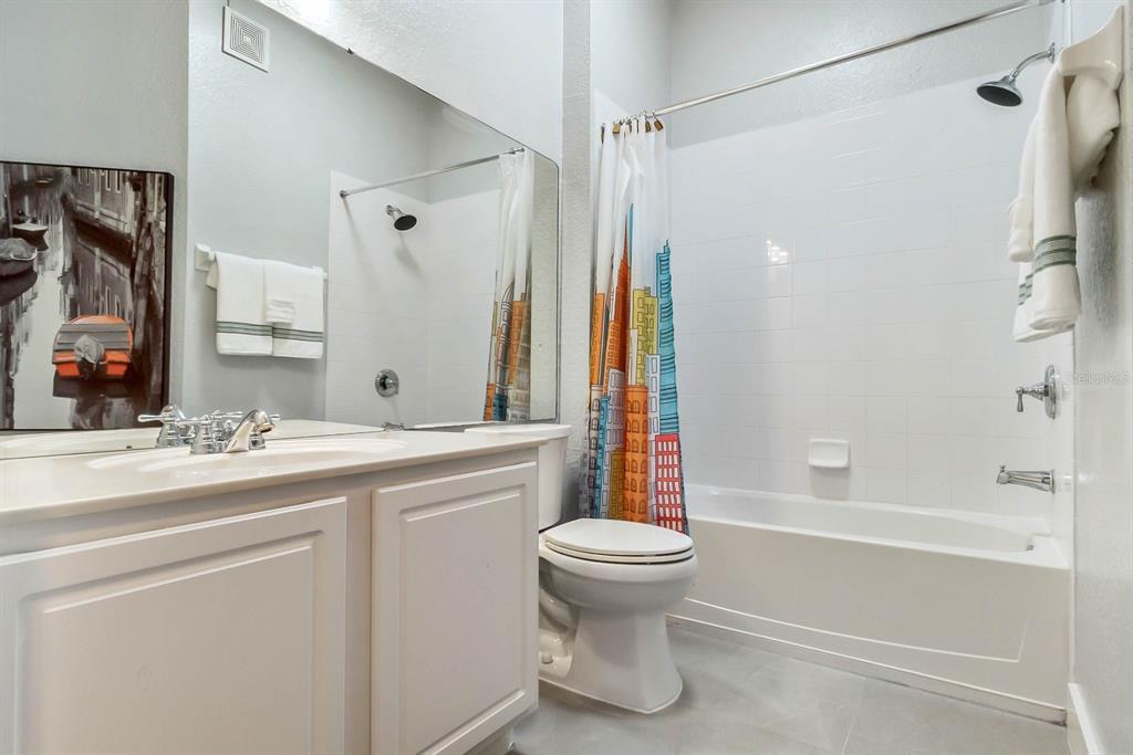 5049 Shoreway Loop, Unit 40601 Orlando, FL 32819 - Photo 14 of 28 a bathroom with a sink a toilet and a bathtub
