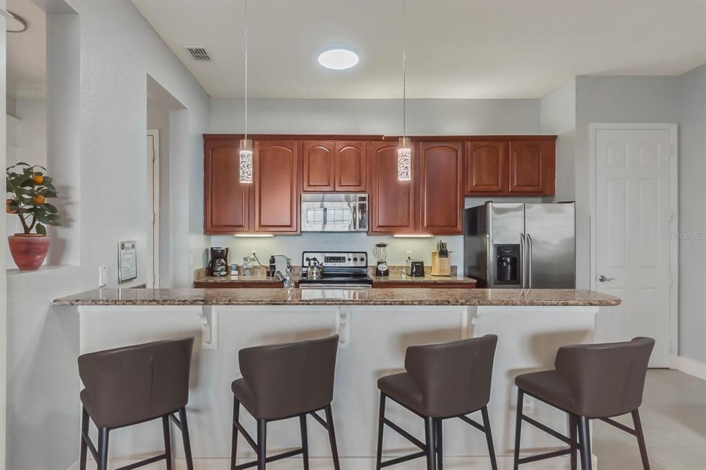 5049 Shoreway Loop, Unit 40601 Orlando, FL 32819 - Photo 4 of 28 a kitchen with stainless steel appliances granite countertop a stove a sink dishwasher a microwave oven with granite countertops and cabinets