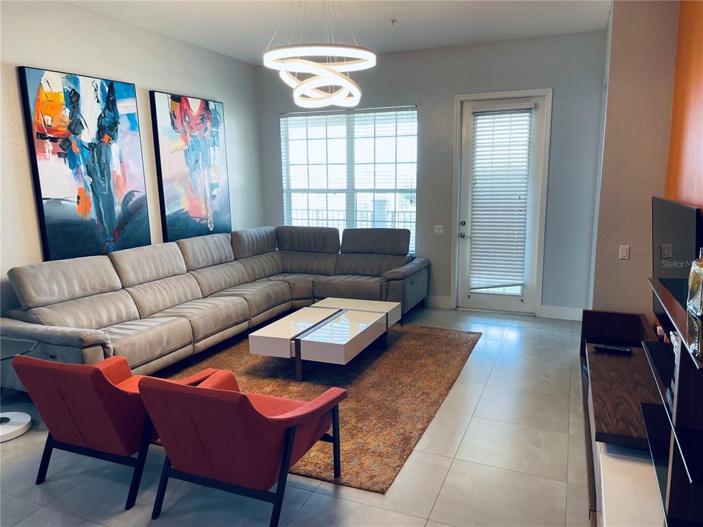 5049 Shoreway Loop, Unit 40601 Orlando, FL 32819 - Photo 8 of 28 a living room with furniture and a window