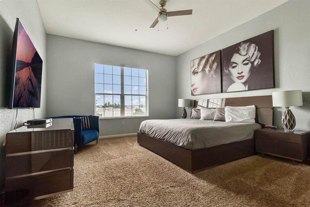 5049 Shoreway Loop, Unit 40601 Orlando, FL 32819 - Photo 9 of 28 a bedroom with a bed and a flat screen tv
