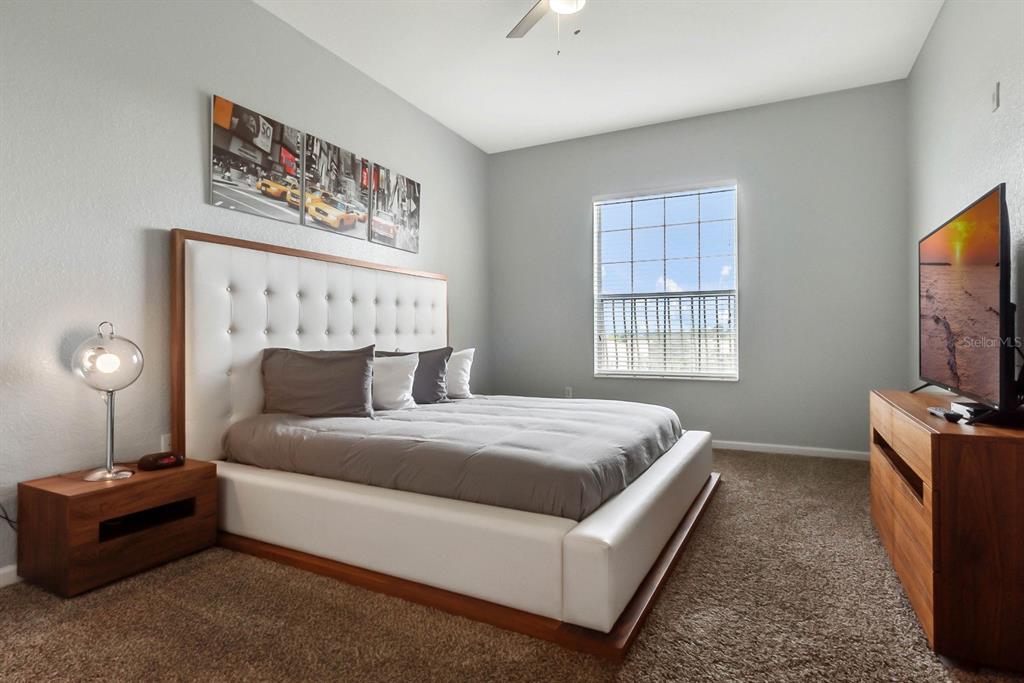 5049 Shoreway Loop, Unit 40601 Orlando, FL 32819 - Photo 10 of 28 a bedroom with bed and a flat screen tv