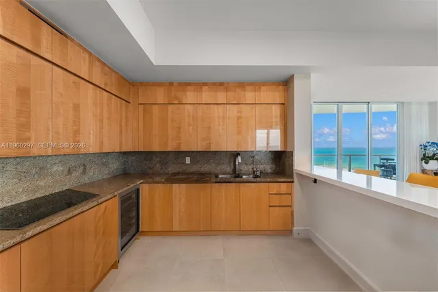 a kitchen with granite countertop a sink a counter space and cabinets