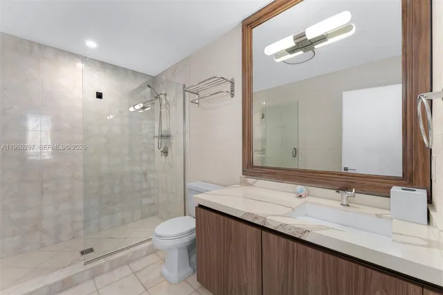 a bathroom with a granite countertop sink a toilet a mirror and shower