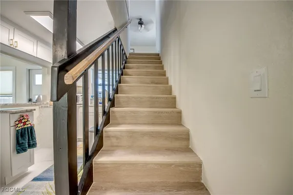 a view of staircase with lots of frames on wall and a window