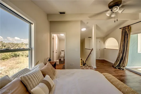 a living room with furniture a large window and wooden floor