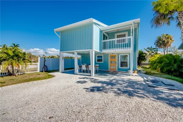 a view of a house with a yard and potted plants