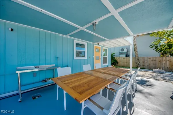 a view of a patio with table and chairs near a yard