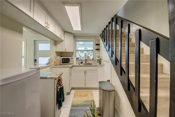 a open kitchen with sink microwave stove and refrigerator