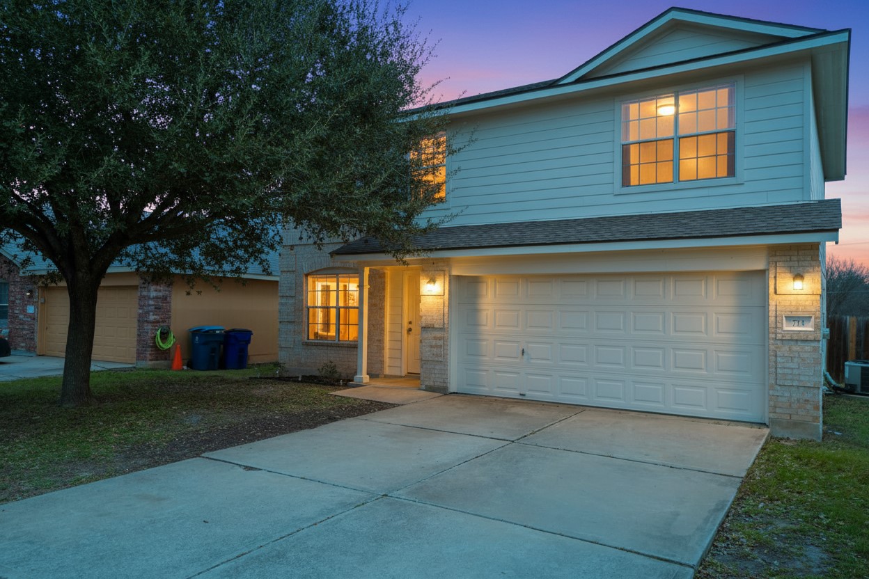 Traditional home with concrete driveway, an attached garage, and brick siding