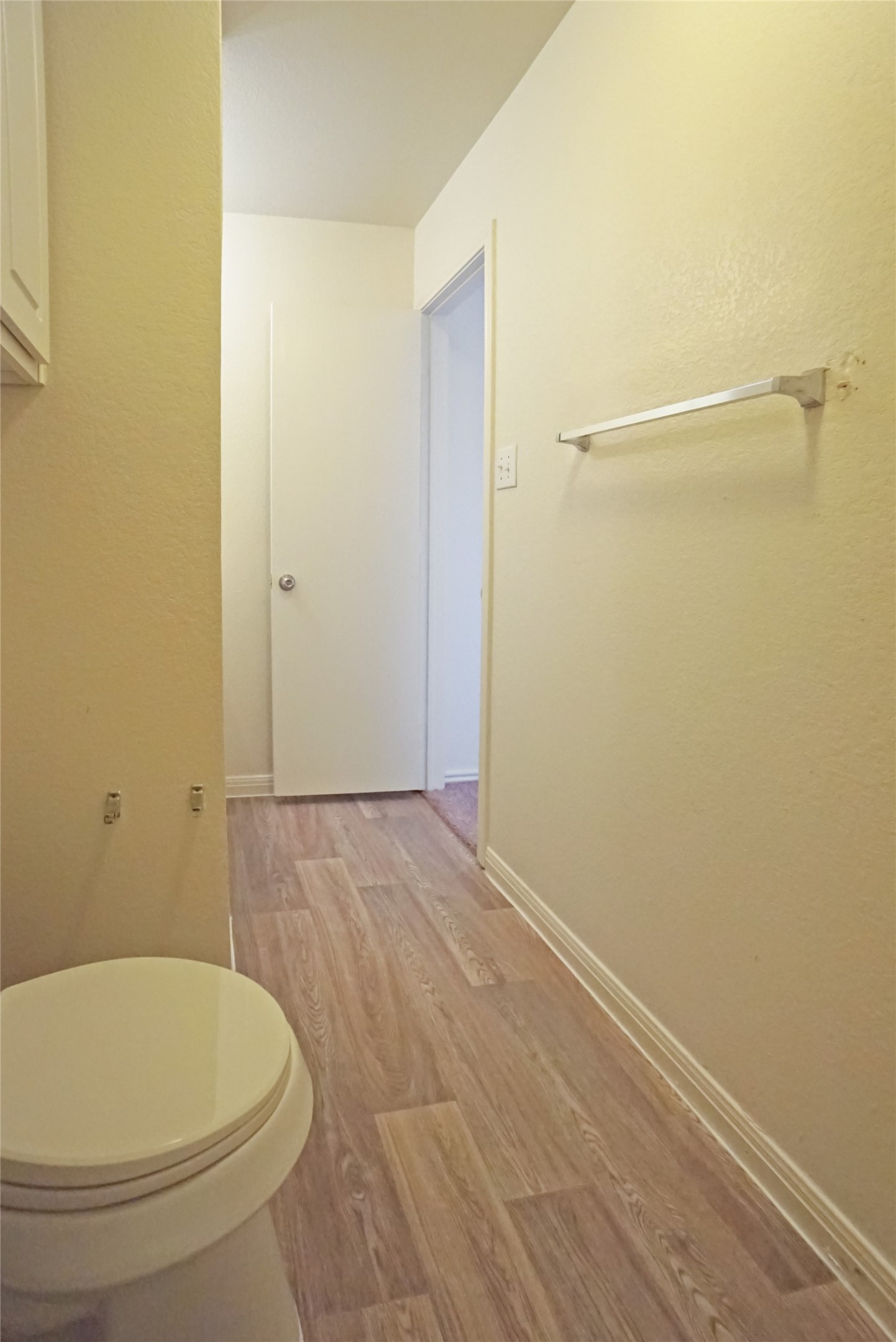 714 Lavaca Loop Elgin, TX 78621 - Photo 16 of 38 Bathroom featuring light wood-style floors and a textured wall