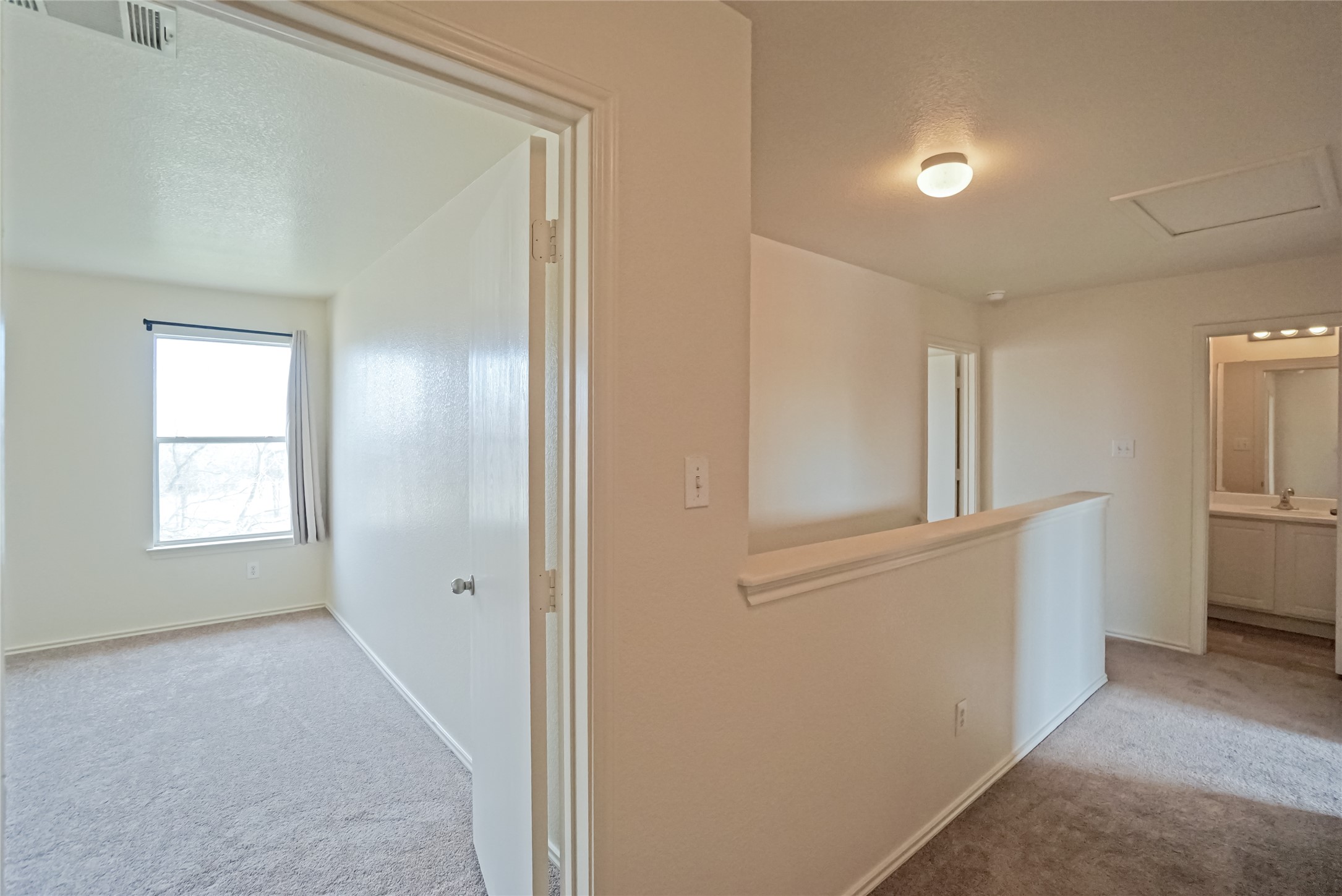 714 Lavaca Loop Elgin, TX 78621 - Photo 28 of 38 Hallway featuring light carpet, a textured ceiling, and an upstairs landing