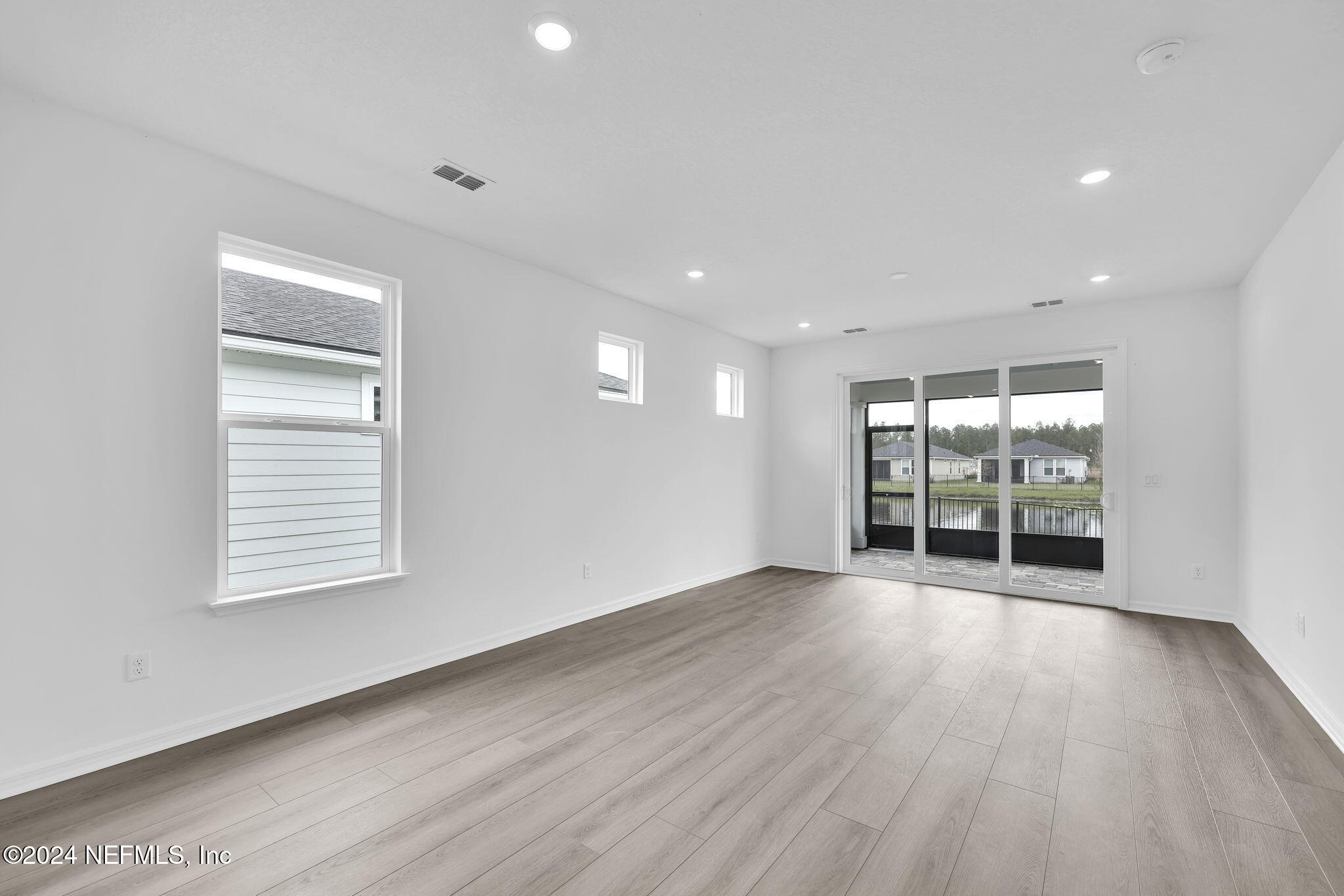 46 Fairlake Circle St. Augustine, FL 32092 - Photo 10 of 45 an empty room with wooden floor and windows