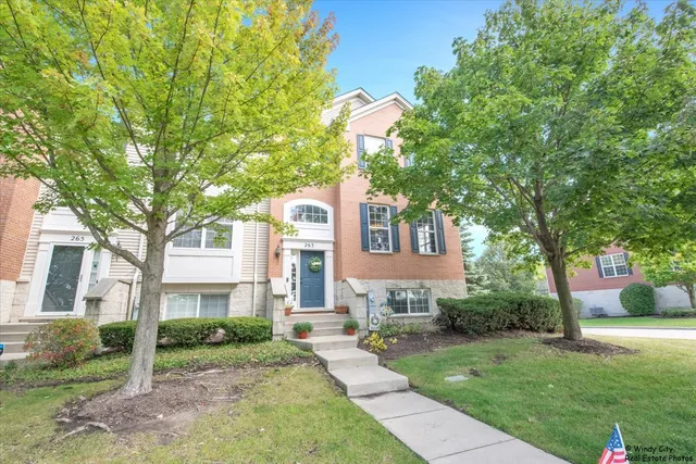 a front view of a house with a yard and trees