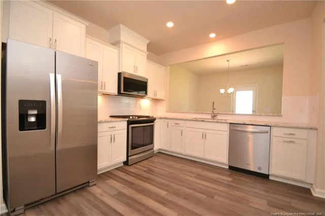 a view of a kitchen with a sink cabinets and wooden floor