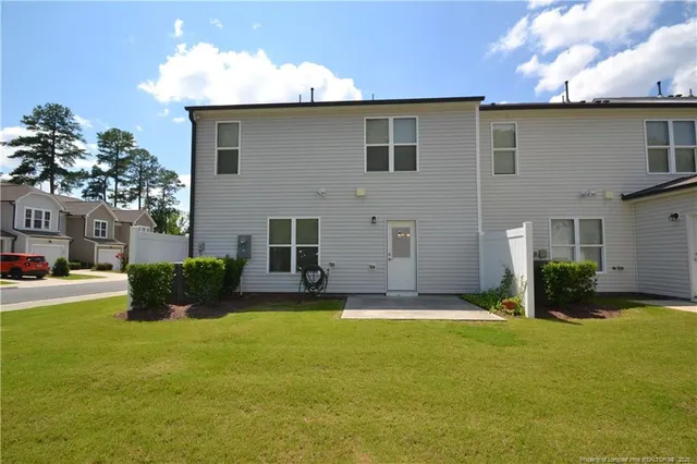 a view of a house with backyard and trees