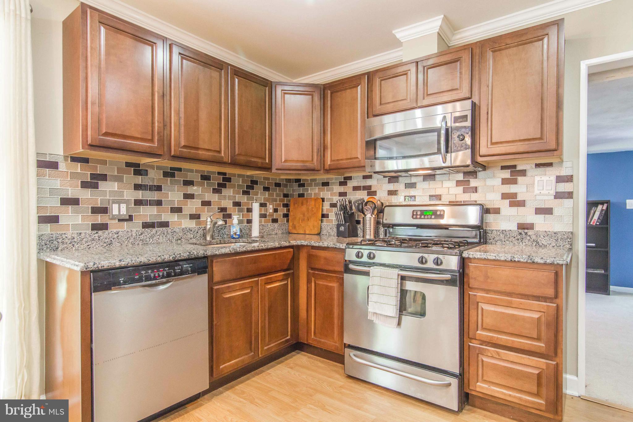 7407 Inzer Street Springfield, VA 22151 - Photo 13 of 29 a kitchen with stainless steel appliances granite countertop a sink stove and cabinets