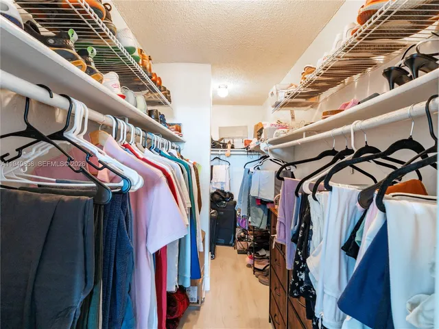 a view of walk in closet with clothes and shoes