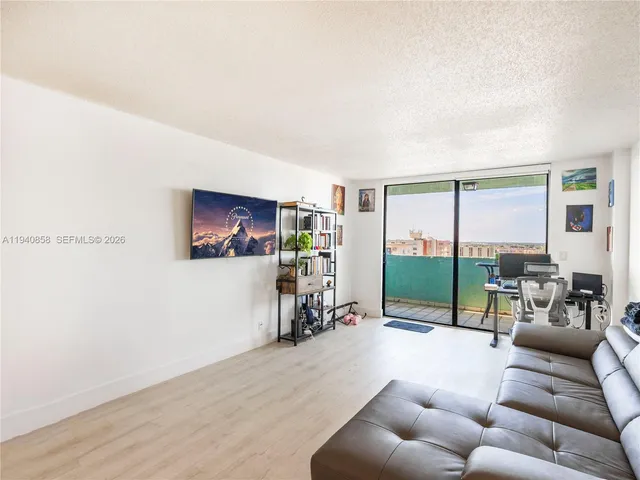 a living room with furniture a ceiling fan and a large window