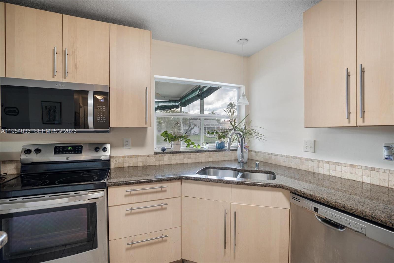 13930 Oak Ridge Drive Davie, FL 33325 - Photo 15 of 54 a kitchen with stainless steel appliances granite countertop a sink a stove and microwave