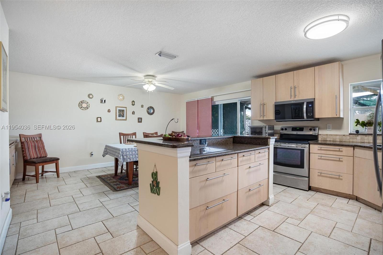 13930 Oak Ridge Drive Davie, FL 33325 - Photo 16 of 54 a kitchen with cabinets and chairs
