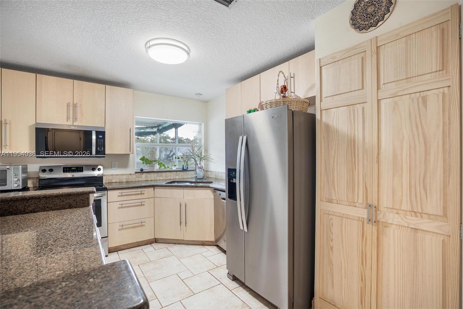 13930 Oak Ridge Drive Davie, FL 33325 - Photo 17 of 54 a kitchen with stainless steel appliances granite countertop a refrigerator and a stove top oven