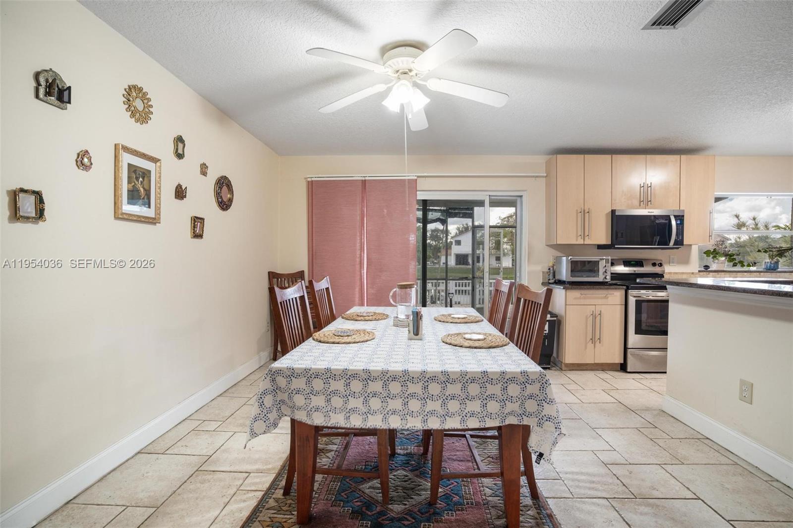 13930 Oak Ridge Drive Davie, FL 33325 - Photo 18 of 54 a kitchen with stainless steel appliances kitchen island granite countertop a refrigerator a stove a sink dishwasher with a dining table and chairs