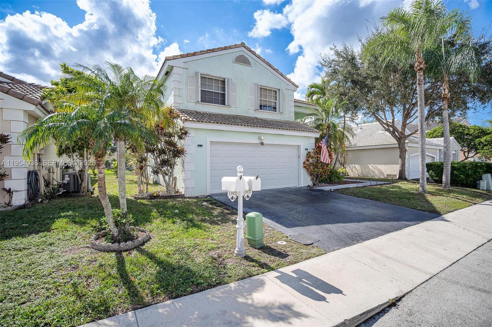 13930 Oak Ridge Drive Davie, FL 33325 - Photo 2 of 54 a front view of a house with garden