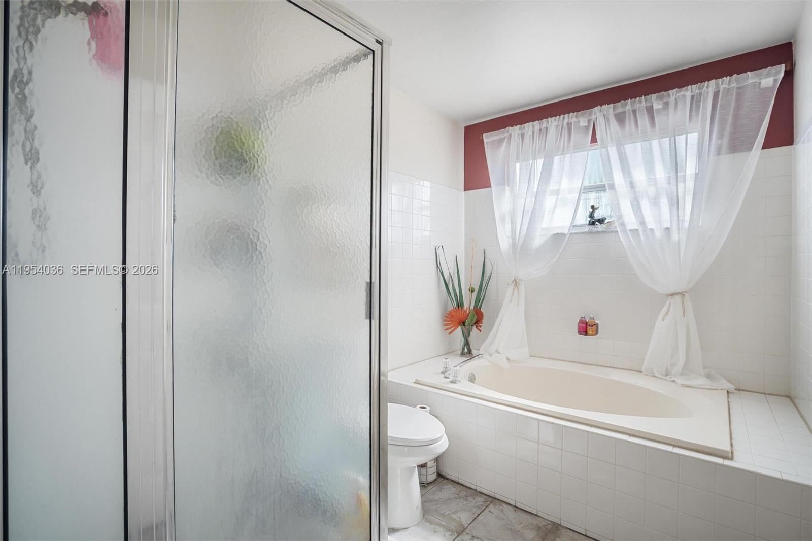 13930 Oak Ridge Drive Davie, FL 33325 - Photo 30 of 54 a bathroom with a bathtub and a shower