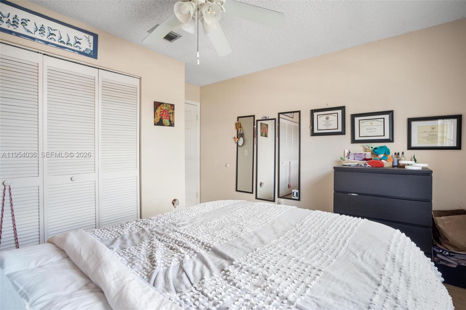13930 Oak Ridge Drive Davie, FL 33325 - Photo 33 of 54 a bedroom with a bed and a chandelier