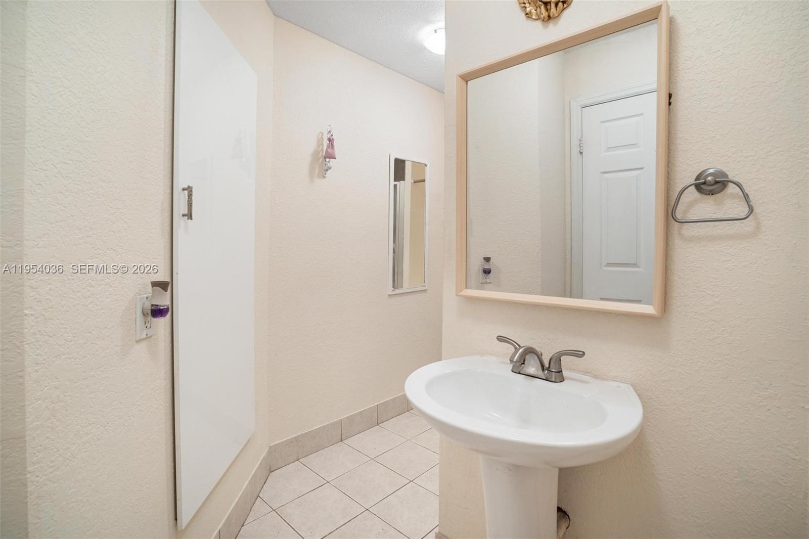 13930 Oak Ridge Drive Davie, FL 33325 - Photo 38 of 54 a bathroom with a sink a mirror and a shower