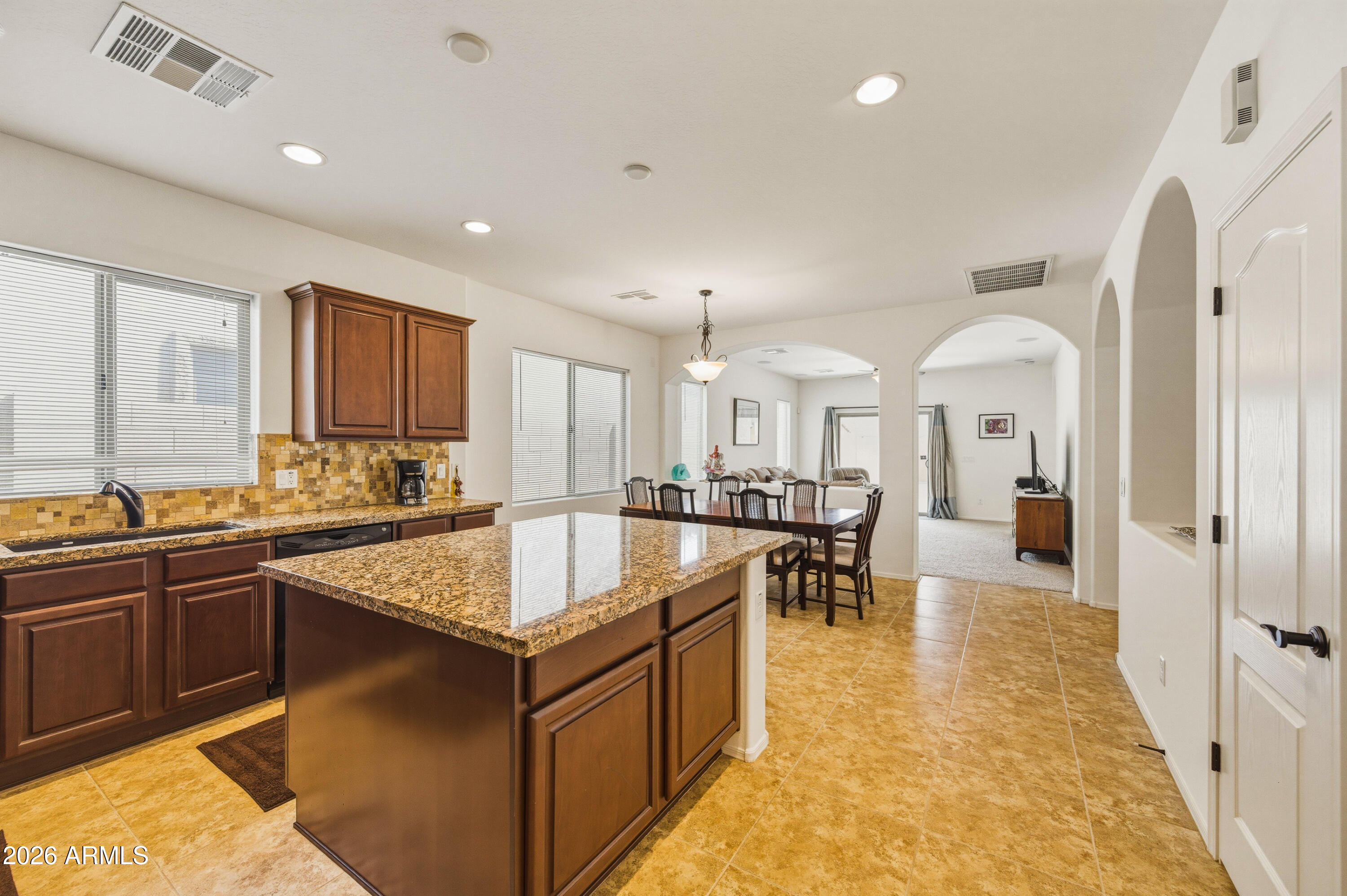 a large kitchen with kitchen island a sink table and chairs