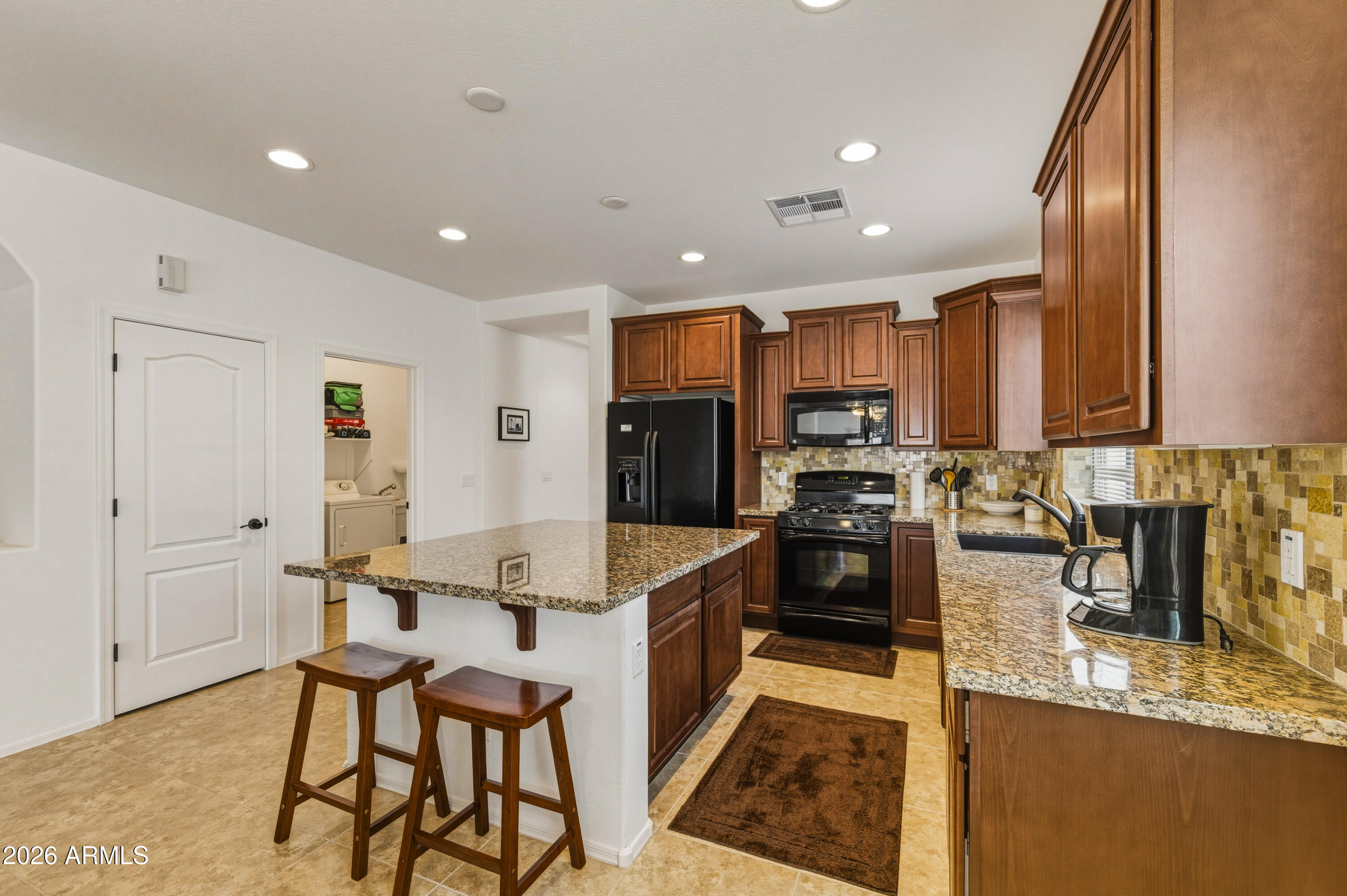 38061 West Merced Street Maricopa, AZ 85138 - Photo 17 of 49 a large kitchen with granite countertop lots of counter space and stainless steel appliances