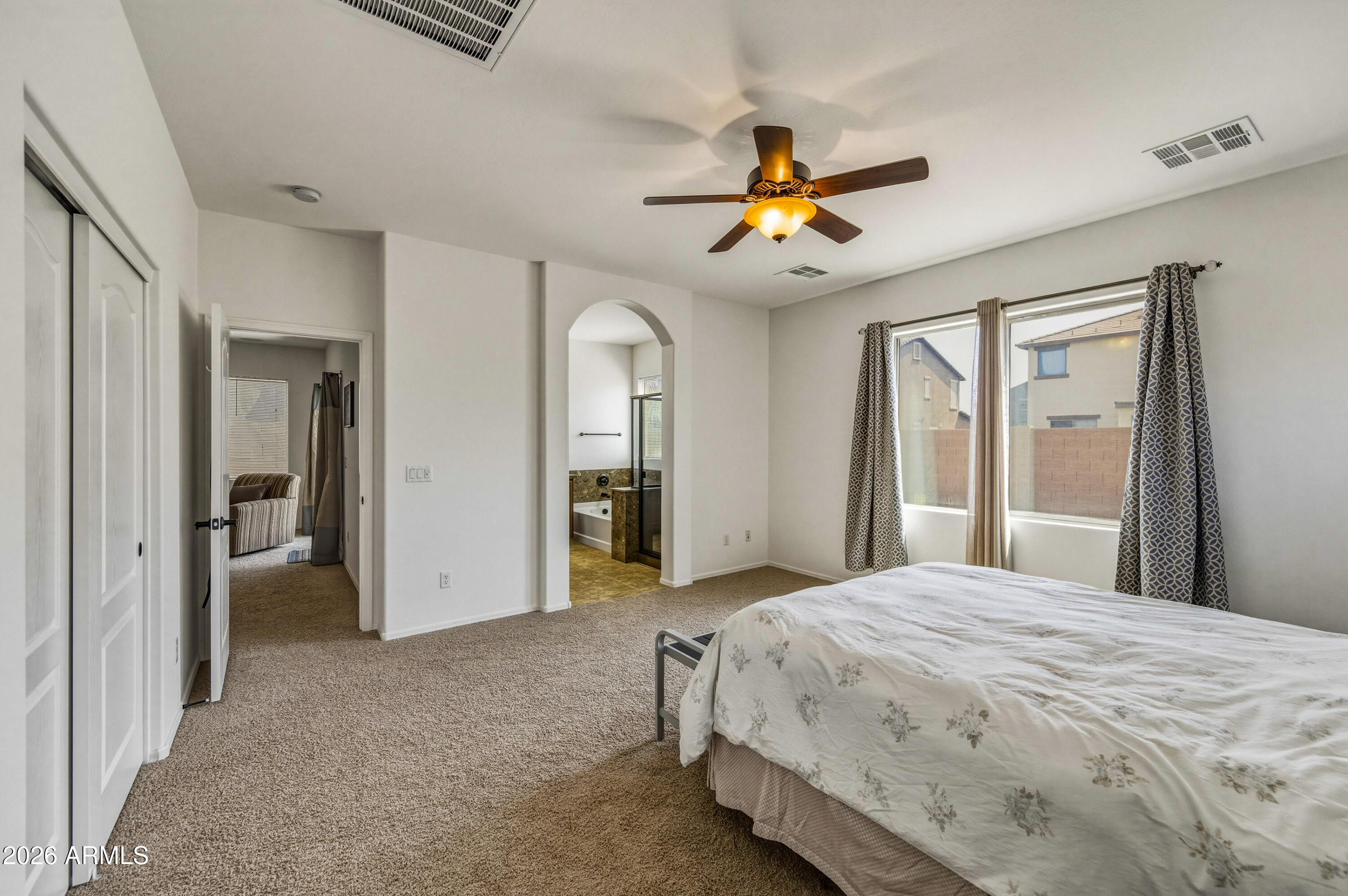 38061 West Merced Street Maricopa, AZ 85138 - Photo 24 of 49 a bedroom with a bed and a chandelier