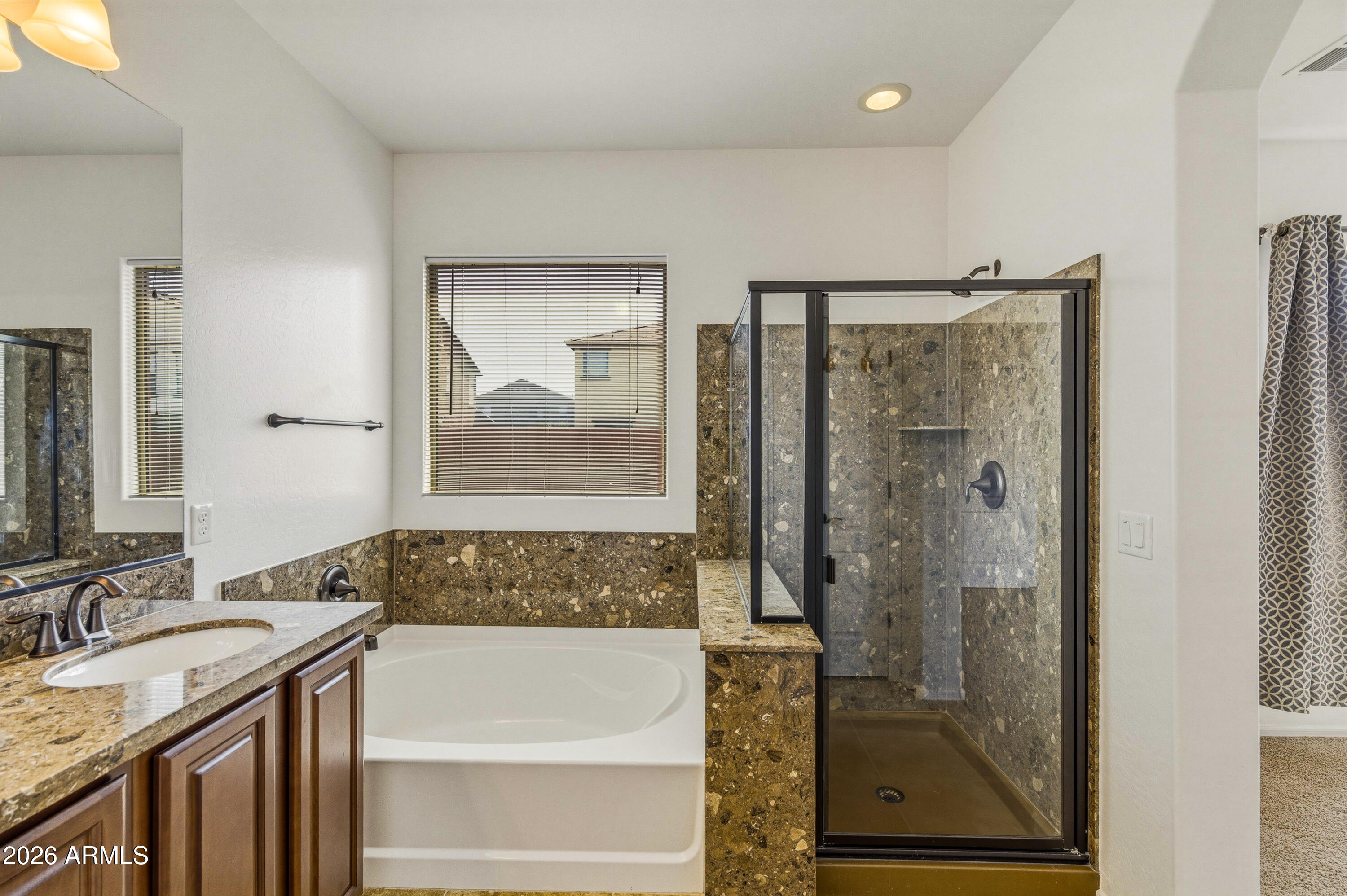 38061 West Merced Street Maricopa, AZ 85138 - Photo 28 of 49 a bathroom with a granite countertop sink a mirror and a bathtub
