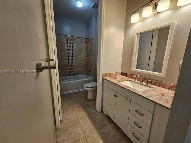 a bathroom with a double vanity sink toilet and shower