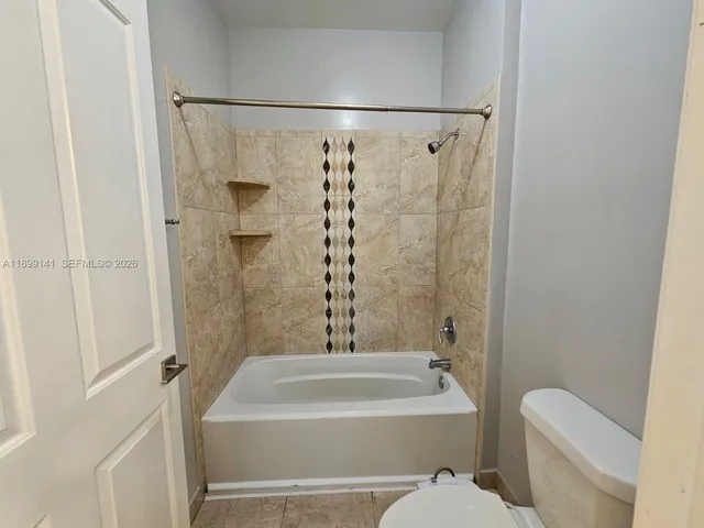 a bathroom with a shower a toilet and a tub