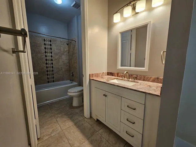 a bathroom with a double vanity sink toilet mirror and shower